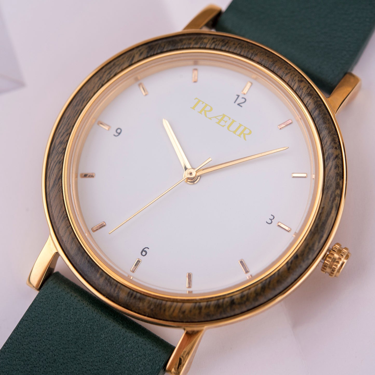 Elegant Træur wristwatch with gold case, wood-textured bezel, white dial, and green leather strap